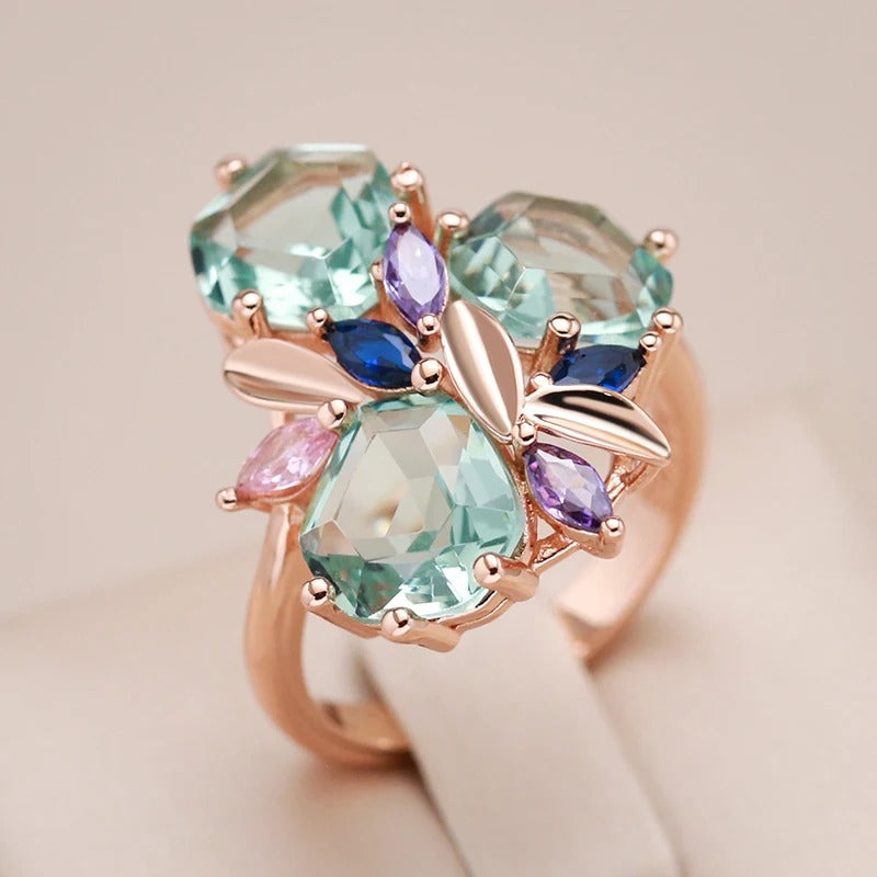 18k rose gold ring in a shape of a flower with aquamarine stones inlaid